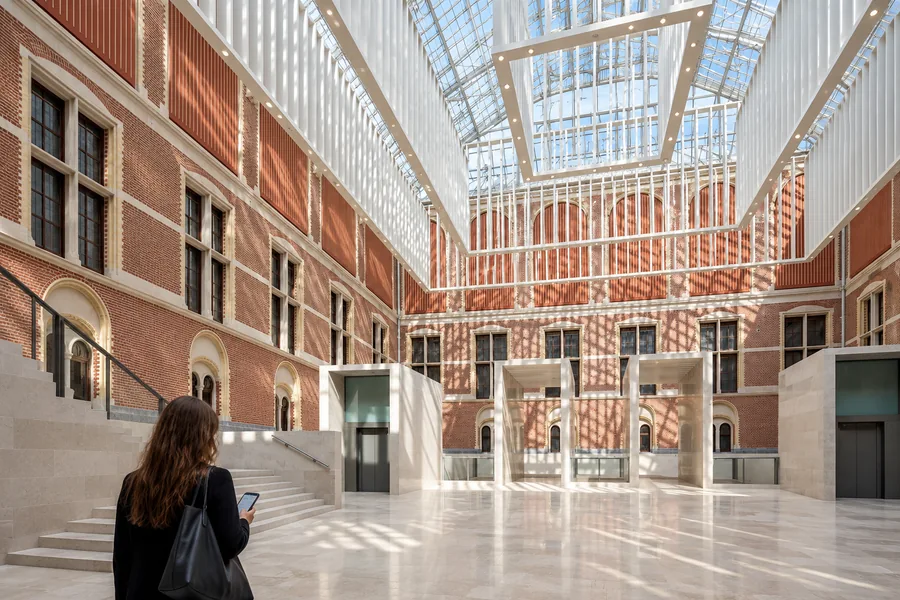 Visitor checking a phone before entering the Rijksmuseum galleries